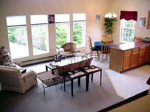 Looking into the living room from the stairs, with the dining area to the side