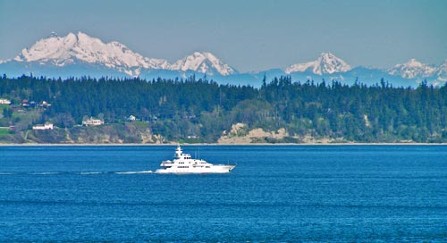 Watching a boat pass snow-covered Cascades peaks
